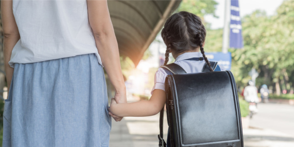 Mother taking her kid to school after scheduling her time with Parents Gateway